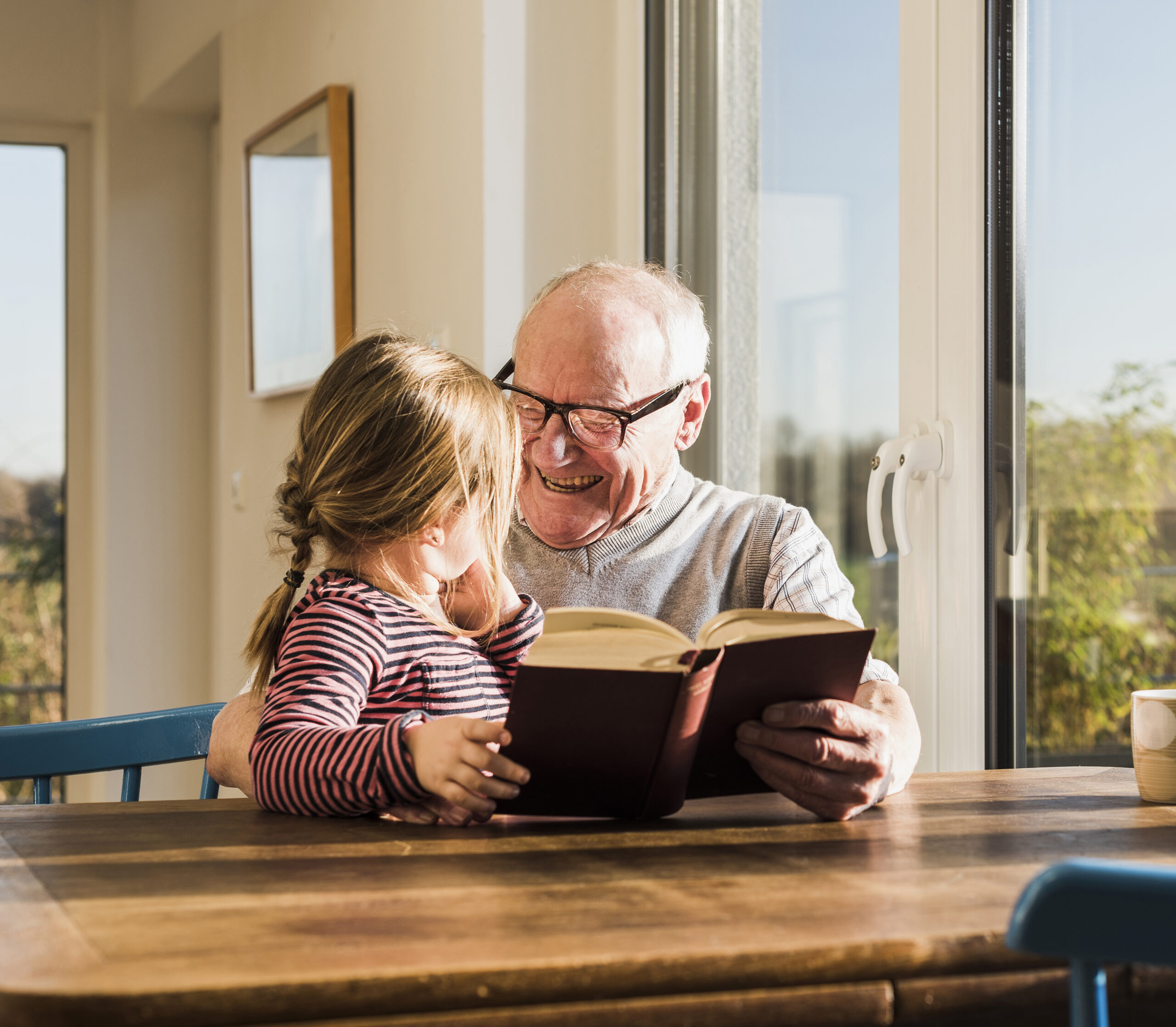 Grandfather reading out story for his granddaughter